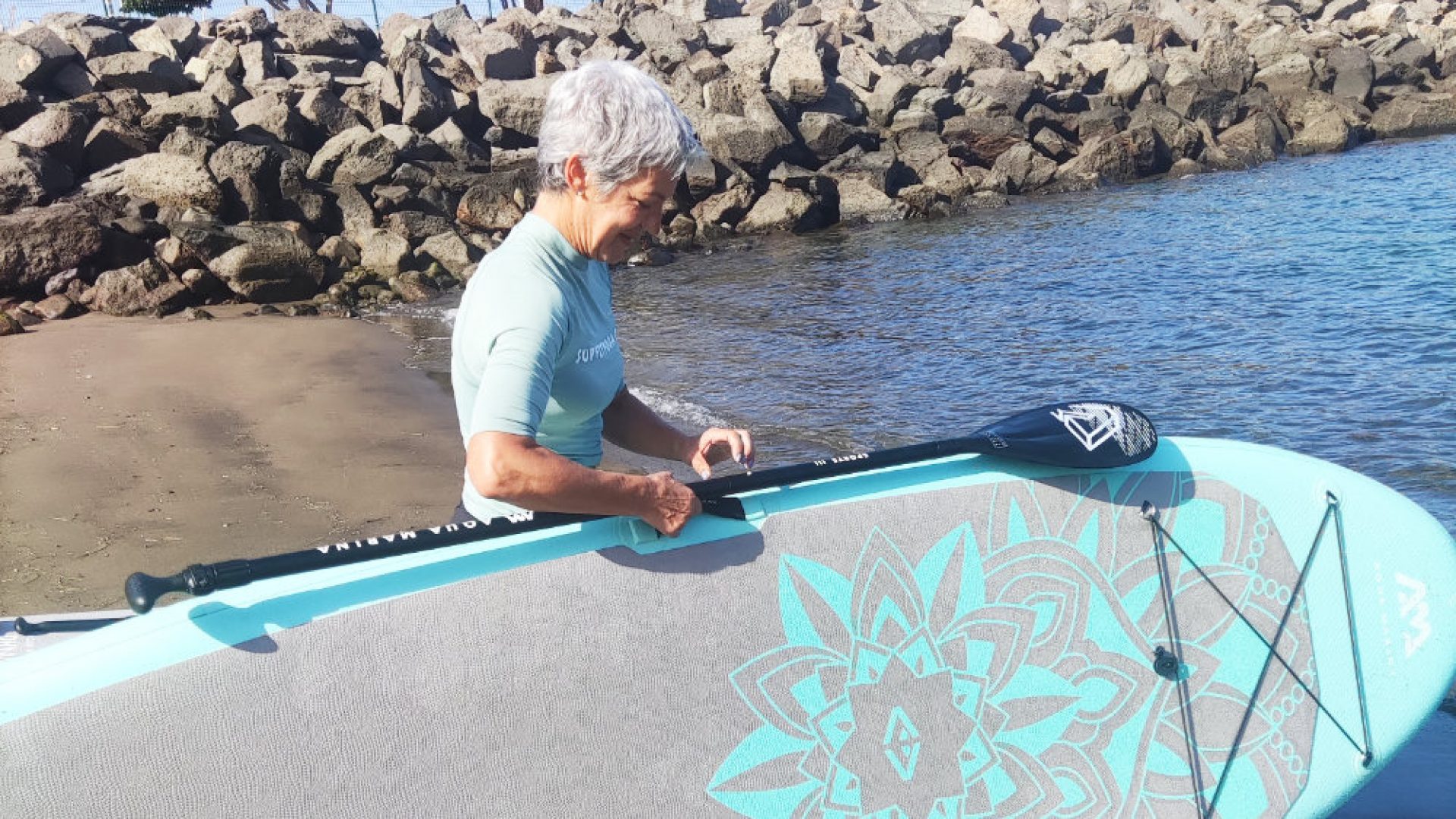 Chica alquila su tabla de paddle surf en Arguineguín